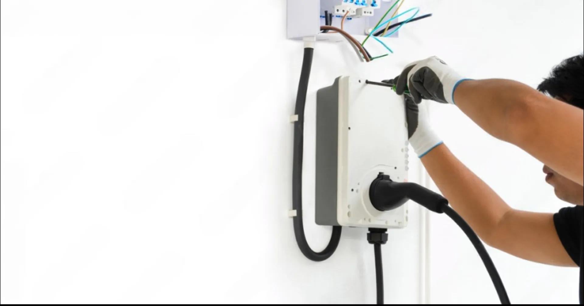 Electrician installing a residential Level 2 EV wall charger
